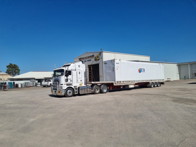 Kenworth K200 transporting a modular building